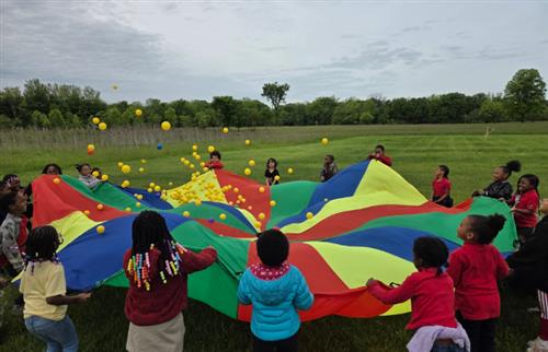  children playing with the parachute